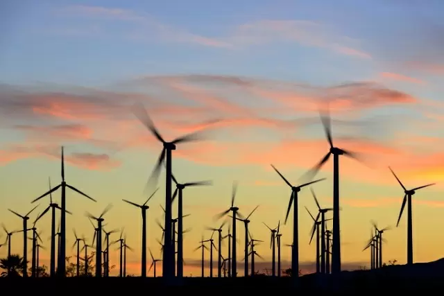 Wind Power - EnvironmentalScience.org Wind turbines silhouetted against colorful sunset sky at modern wind farm